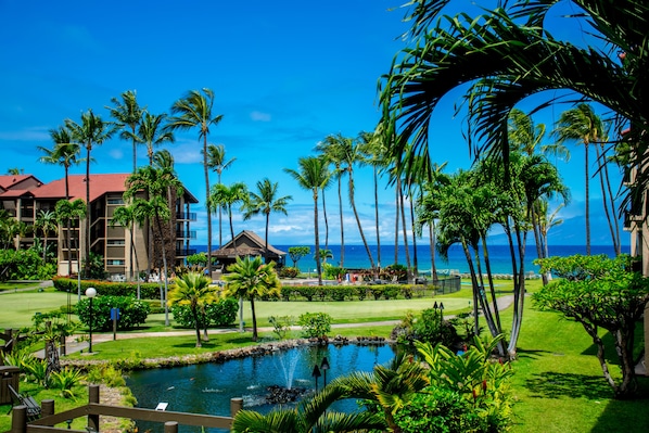 Un resort con piscina, palmeras y vista al océano.