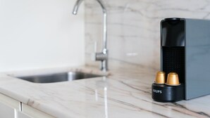 A kitchen with a marble countertop, a modern faucet, and a coffee machine with two capsules. - GuestReady - Almada 516 Stay (Porto)