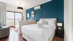 Une chambre d’hôtel moderne avec un grand lit, un bureau et une vue sur la ville.