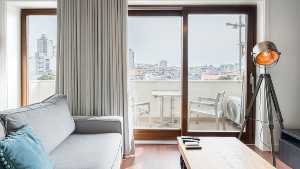 Un salon moderne avec un canapé gris, une table basse en bois et un lampadaire.