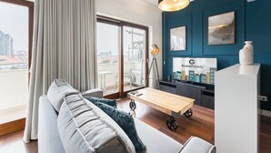 Un salon moderne avec un canapé, une table basse et un téléviseur affichant le logo « GuestReady ».