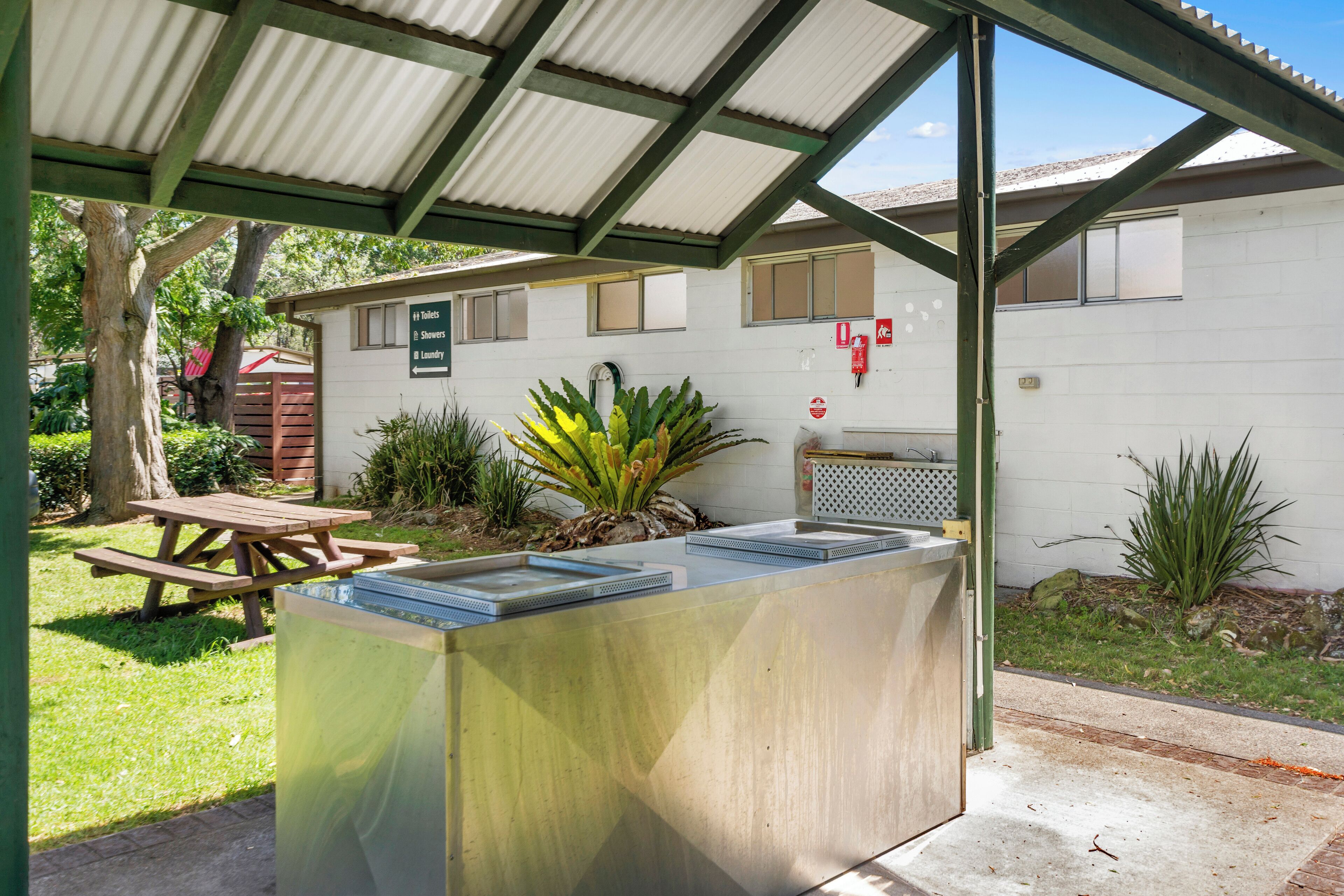 A covered picnic area with a table and a water fountain.