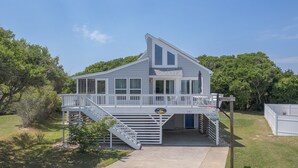 A two-story house with a balcony and a covered porch, surrounded by trees and a well-maintained lawn. - 4002 - Duffy Duck - Heart of Duck Escape w/ Pool & Hot Tub (Duck)