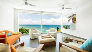 A spacious balcony with a view of the ocean, furnished with white chairs, a sofa, and a wooden coffee table. - VILLA VICTORIA FACING THE SEA (Le Gosier)