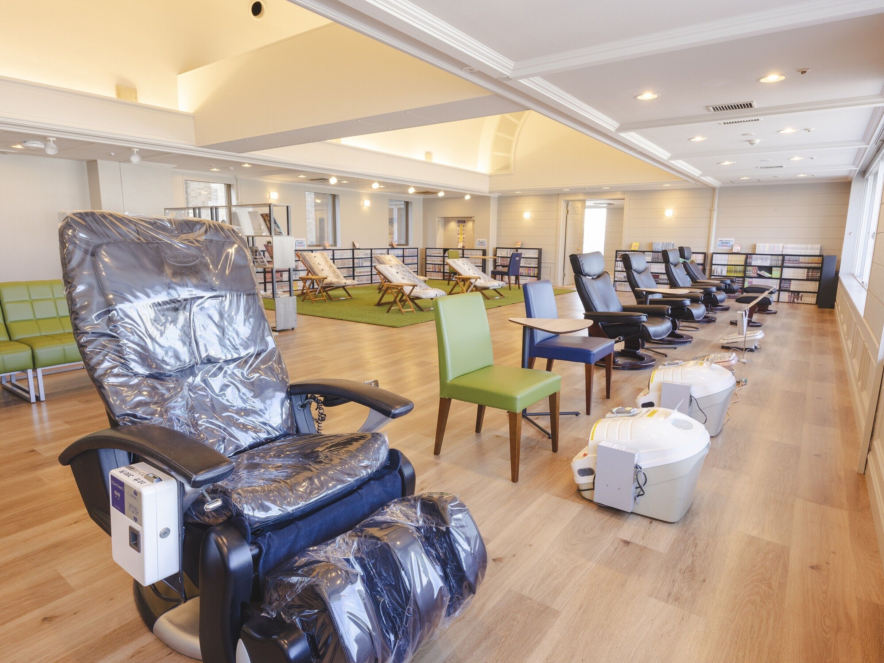 A modern spa with multiple massage chairs, a reception area, and a library.