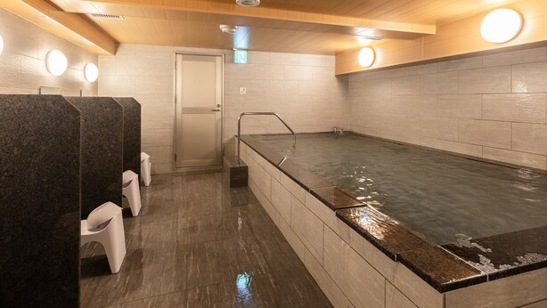 En bastu med ett träpanelat tak, en stor uppvärmd pool och en dörr som leder till ett annat rum.