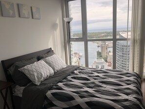 Enjoy a city view from the large window, with a comfortable bed and modern decor.