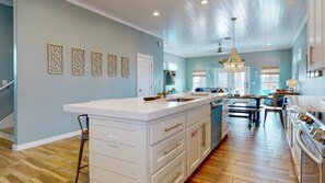 A spacious kitchen with a large island, white cabinetry, and a wooden floor. - Private Heated Pool, Golf Cart Included, Great Parking, Old Town Location (Port Aransas)