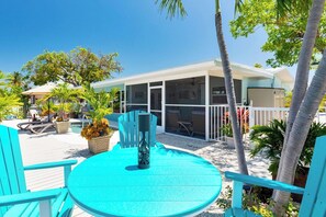 A poolside area with turquoise chairs and a table, surrounded by palm trees and a covered seating area. - P52 - Canal front, 2 bedroom, 3 bath with private pool and dockage (Marathon)