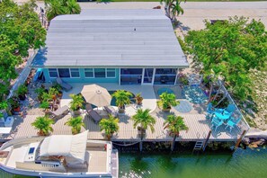 A large house with a pool, outdoor seating, and a boat dock. - P52 - Canal front, 2 bedroom, 3 bath with private pool and dockage (Marathon)
