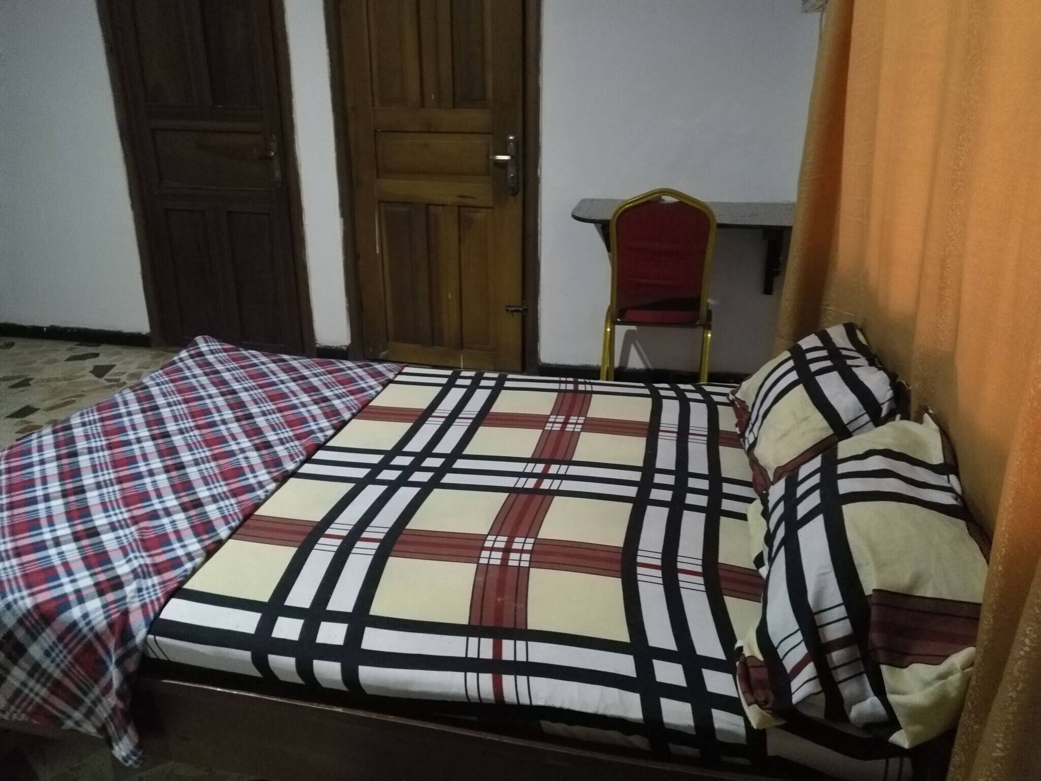 Une chambre à coucher avec un lit, une chaise et une porte.