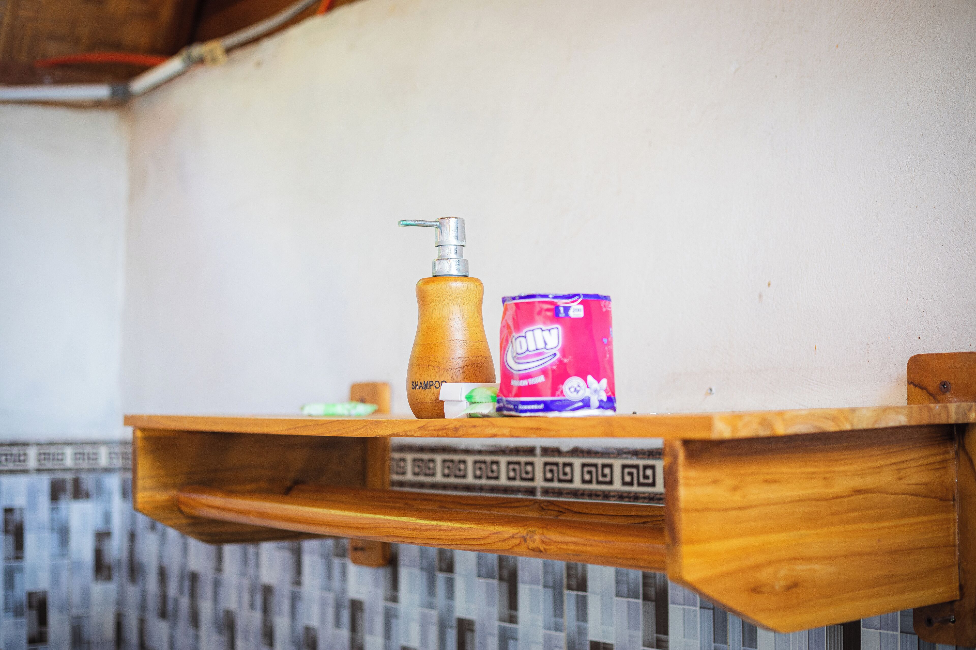 A wooden shelf with a wooden bottle, a red can, and a small container.