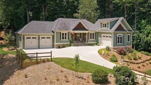Ein zweistöckiges Haus mit Auffahrt, Garage und angelegtem Garten.