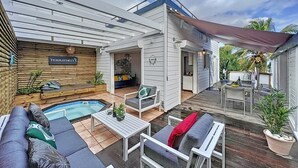 A modern outdoor living area with a pool, seating, and a covered patio. - TERRATHELY, sea view, private pool, walking distance to beach. (Le Moule)