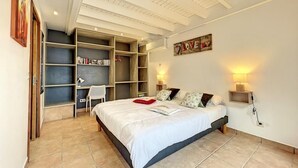 A bedroom with a bed, a desk, and built-in shelving. - TERRATHELY, sea view, private pool, walking distance to beach. (Le Moule)