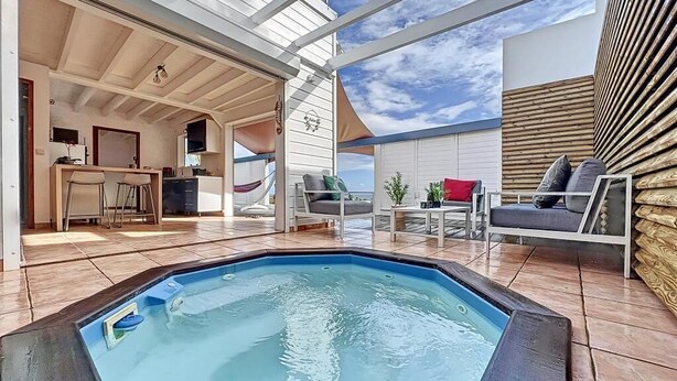 A pool area with a hot tub, seating, and a kitchen area. - TERRATHELY, sea view, private pool, walking distance to beach. (Le Moule)
