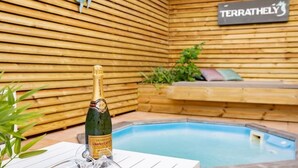 A bottle of champagne, a glass, and a poolside setting with a wooden wall and a sign that reads "TERRATELY". - TERRATHELY, sea view, private pool, walking distance to beach. (Le Moule)