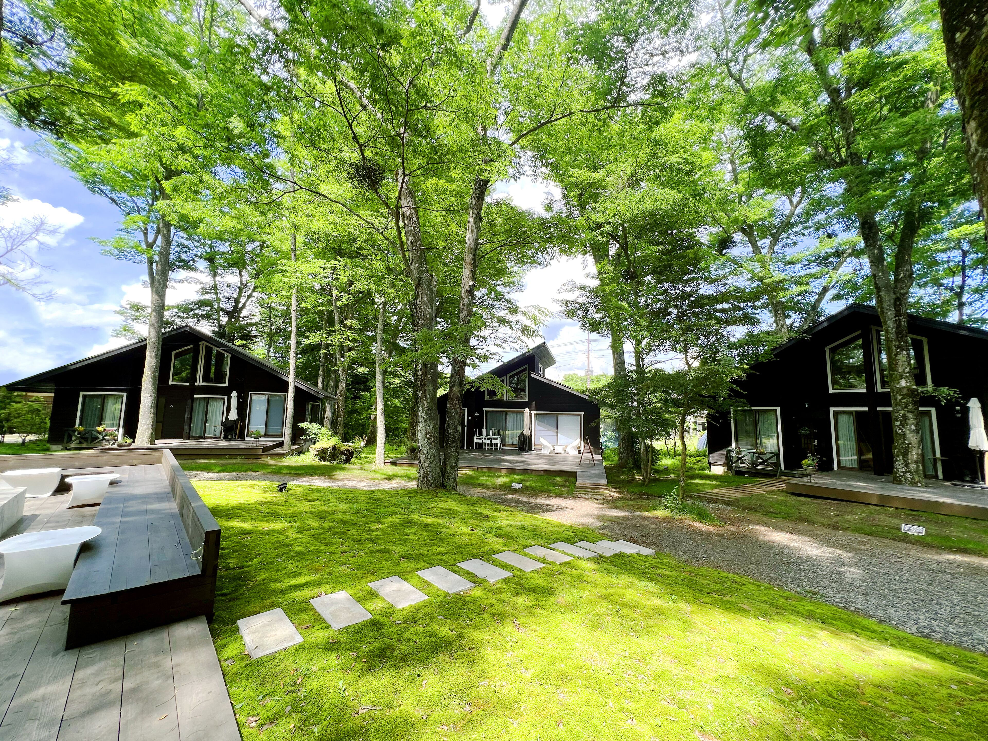 A modern, two-story building with large windows and a covered outdoor seating area.