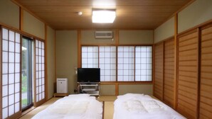 A traditional Japanese room with tatami flooring, a television, and sliding doors. - Forest Villa Yamanakako (Yamanakako)