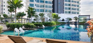 A modern hotel with a swimming pool, palm trees, and a well-maintained garden. - Datum Jelatek Sky Residence KLCC, Five Senses (Ampang)