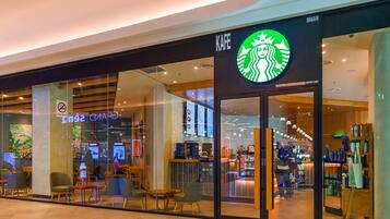 Ein Starbucks Geschäft mit modernem Interieur, Glaswänden und sichtbaren Sitzbereichen durch die Fenster.