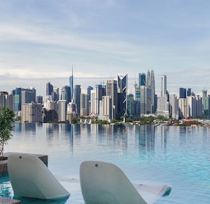 Lo skyline di una città con moderni grattacieli riflessi in una superficie d'acqua calma.