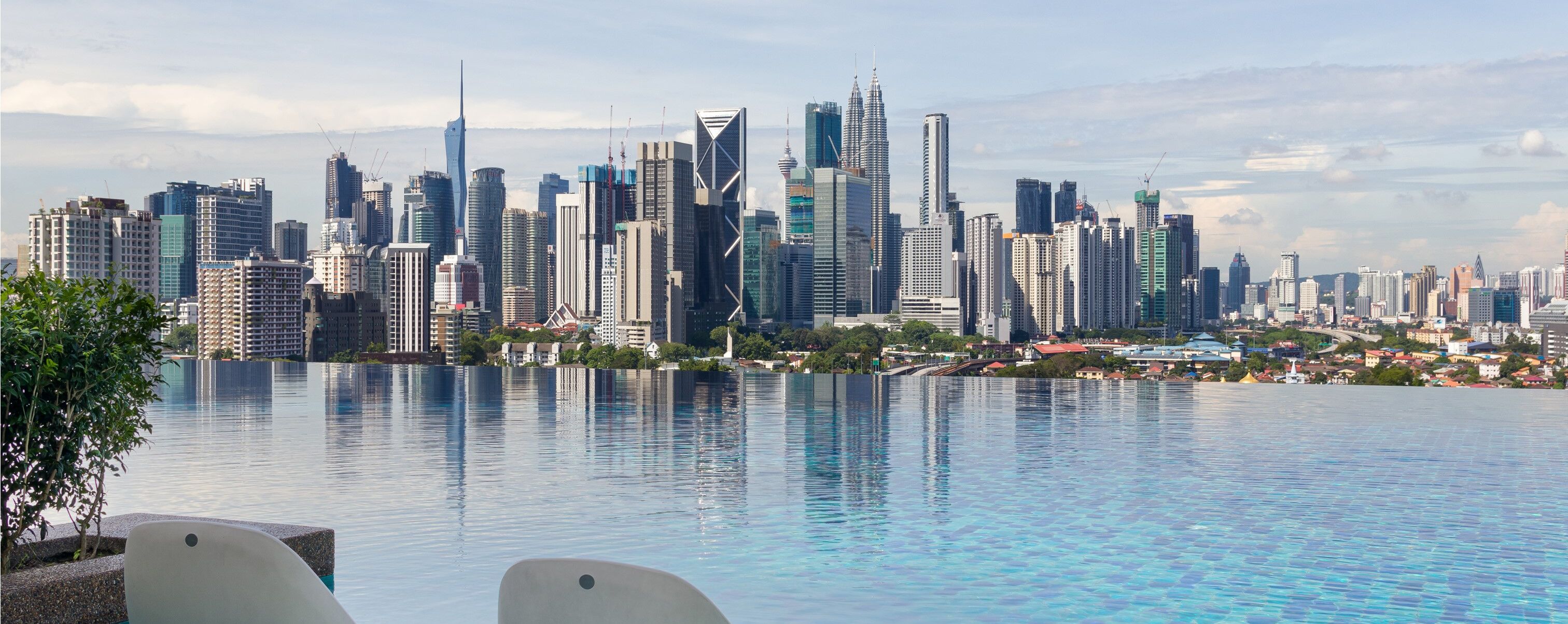 A city skyline with modern skyscrapers and a large body of water in the foreground.