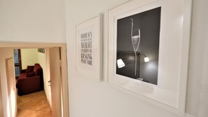 Un couloir orné d’un panneau encadré indiquant les différents types de vin et d’une image encadrée représentant un verre de champagne.