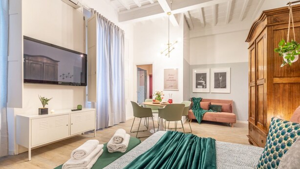 Een moderne hotelkamer met een bed, een bureau, een zithoek en een eethoek.