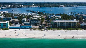 A coastal town with a beach, boats, and buildings.