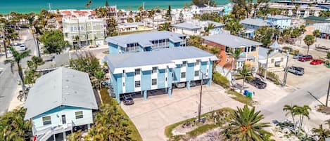A coastal residential area with a prominent blue building, likely a hotel, featuring a flat roof and multiple windows.