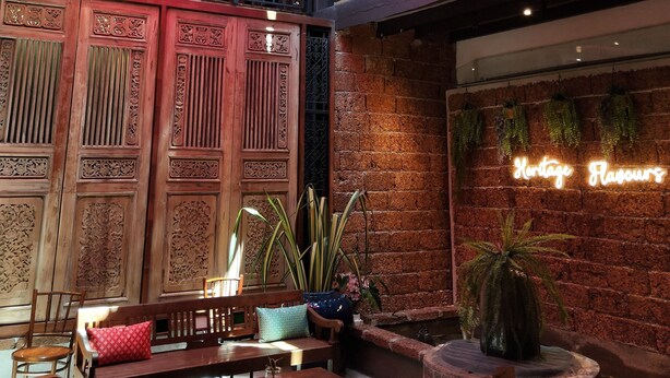 A restaurant with a traditional wooden interior, a neon sign, and colorful umbrellas hanging from the ceiling. - Cloth Art Homestay near Jonker&Pahlawan (Malacca City)
