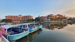 A waterfront with boats docked, buildings with red roofs, and a calm river reflecting the structures. - Cloth Art Homestay near Jonker&Pahlawan (Malacca City)
