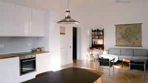 Une cuisine moderne avec des meubles blancs, une table à manger et un ventilateur de plafond.