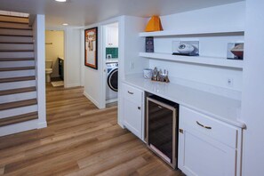 Een moderne keuken met witte kastjes, een ingebouwde oven en een magnetron.