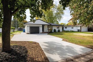 A single-story house with a garage, a driveway, and a lawn. - Cheese Head Hideaway - Walk to Lambeau Field (Green Bay)