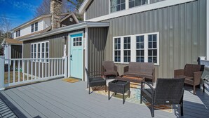 Una terraza con mobiliario de mimbre y una puerta con la inscripción '201'.