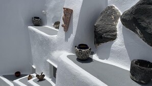 A white-walled building with multiple stone steps, each holding a pot or vase. - Fira 2-Bed Villa, Sleeps 5 with Outdoor Hot Tub (Thera)