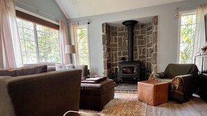 Ein gemütliches Wohnzimmer mit Kamin, Sofa, Sessel und Couchtisch.