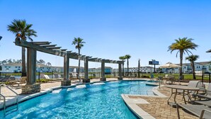 A swimming pool with a pergola structure, lounge chairs, and palm trees. - Modern 3BR Townhome | Pool Access | Near Publix Sports Park & Beaches | Sleeps 9 (Panama City Beach)