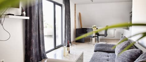 Una sala de estar moderna con un sofá, una mesa de centro y un televisor.