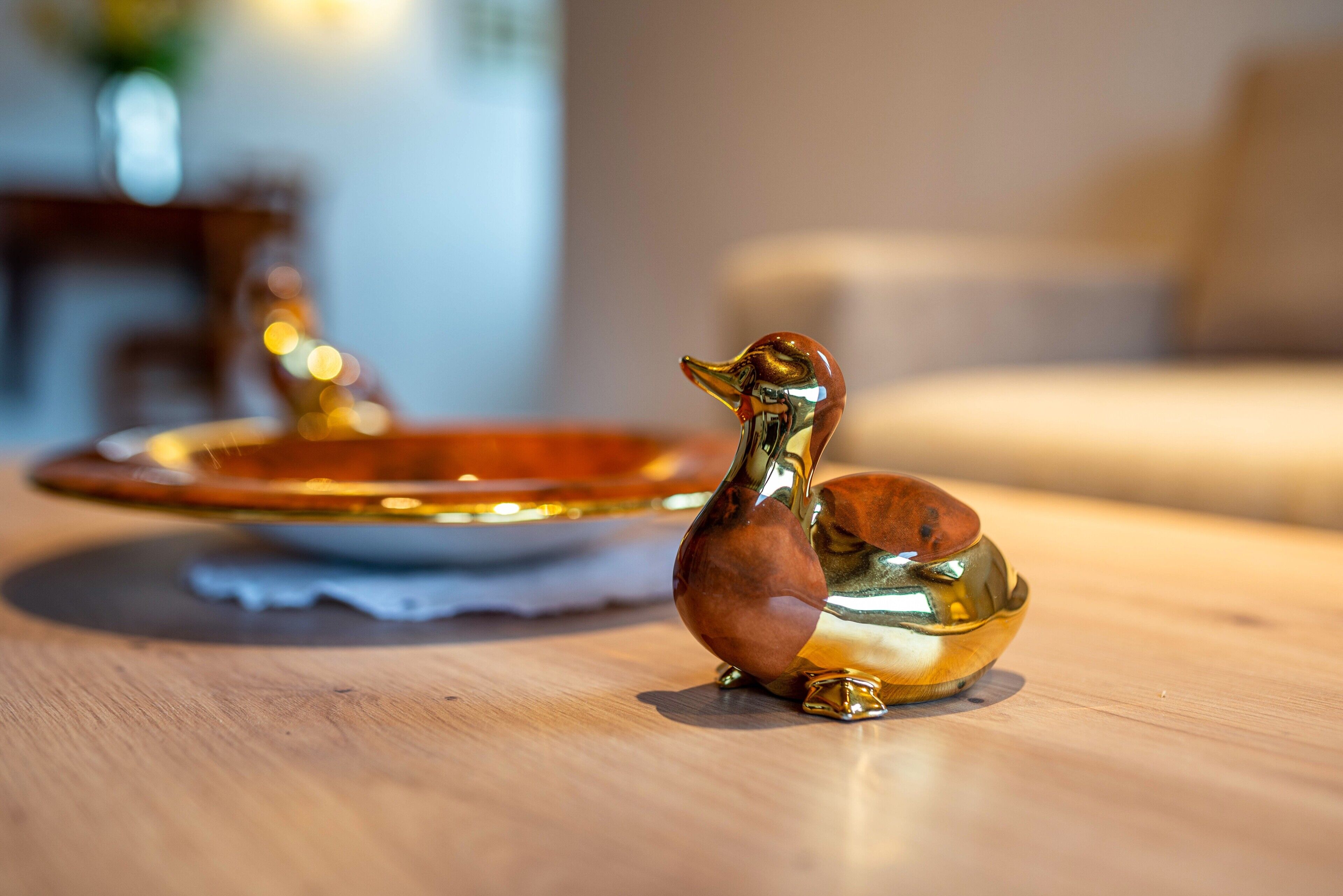 Una figurita de vidrio con forma de pato sobre una superficie de madera.