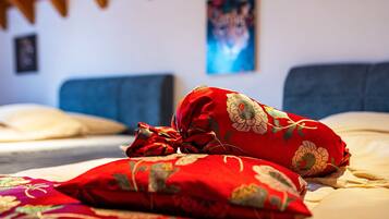 Ein Bett mit roten blumigen Kissen und einem blauen Kopfteil.