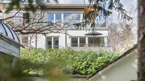Ein modernes Gebäude mit großen Fenstern, einem flachen Dach und einem sichtbaren Schornstein.