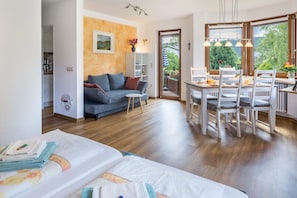 Un salon moderne comprenant un canapé, une table à manger et des chaises, un coin cuisine et un balcon avec vue.