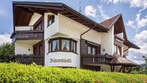 Un bâtiment à l’extérieur texturé, doté de balcons et d’une enseigne indiquant « Bärenhüsli ».