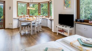 Une chambre comprenant un coin repas, une télévision et deux lits avec des serviettes.