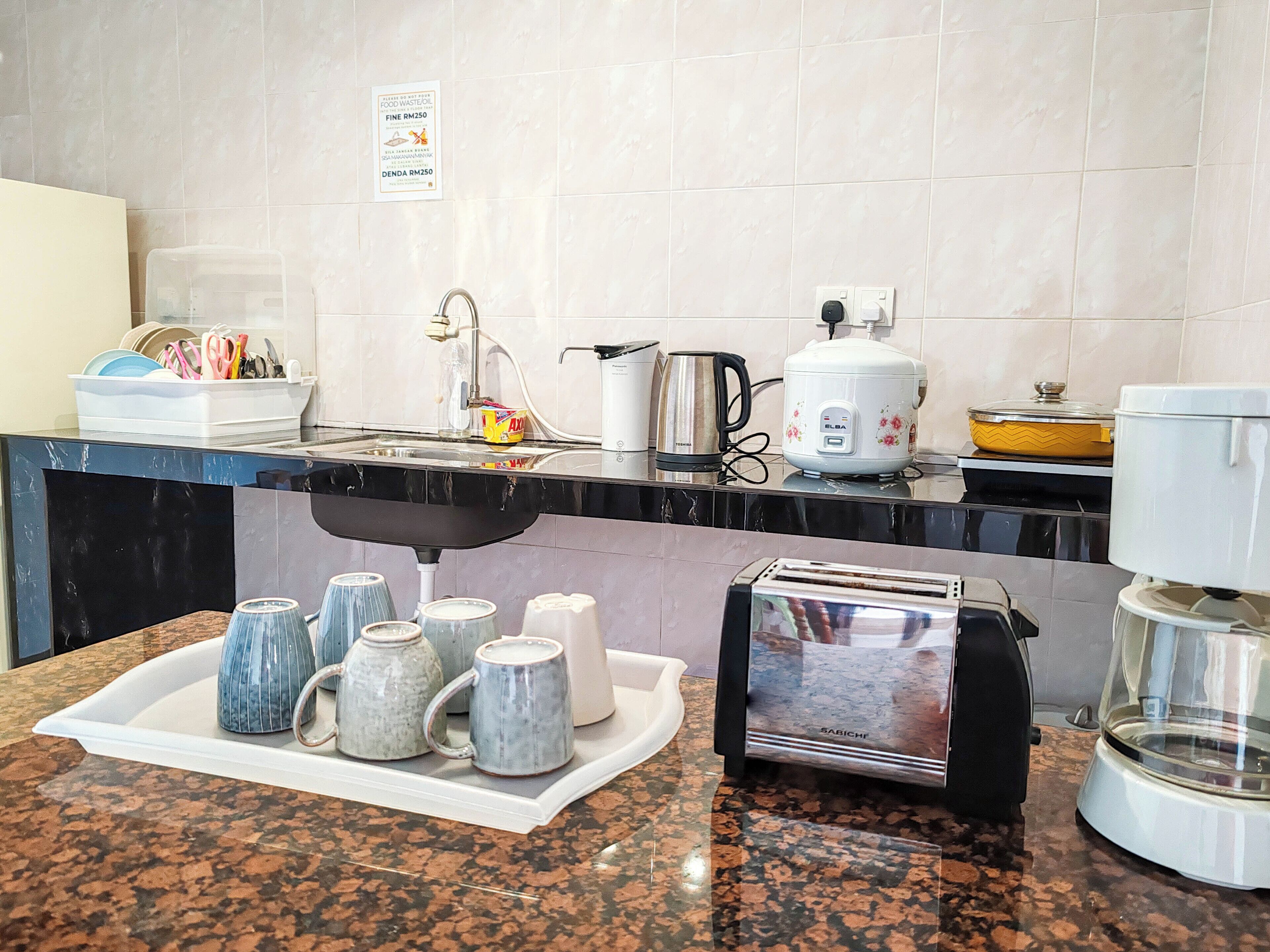Eine Küche mit einer Granitabdeckung, einem Toaster, einem Wasserkocher und einem Reiskocher.