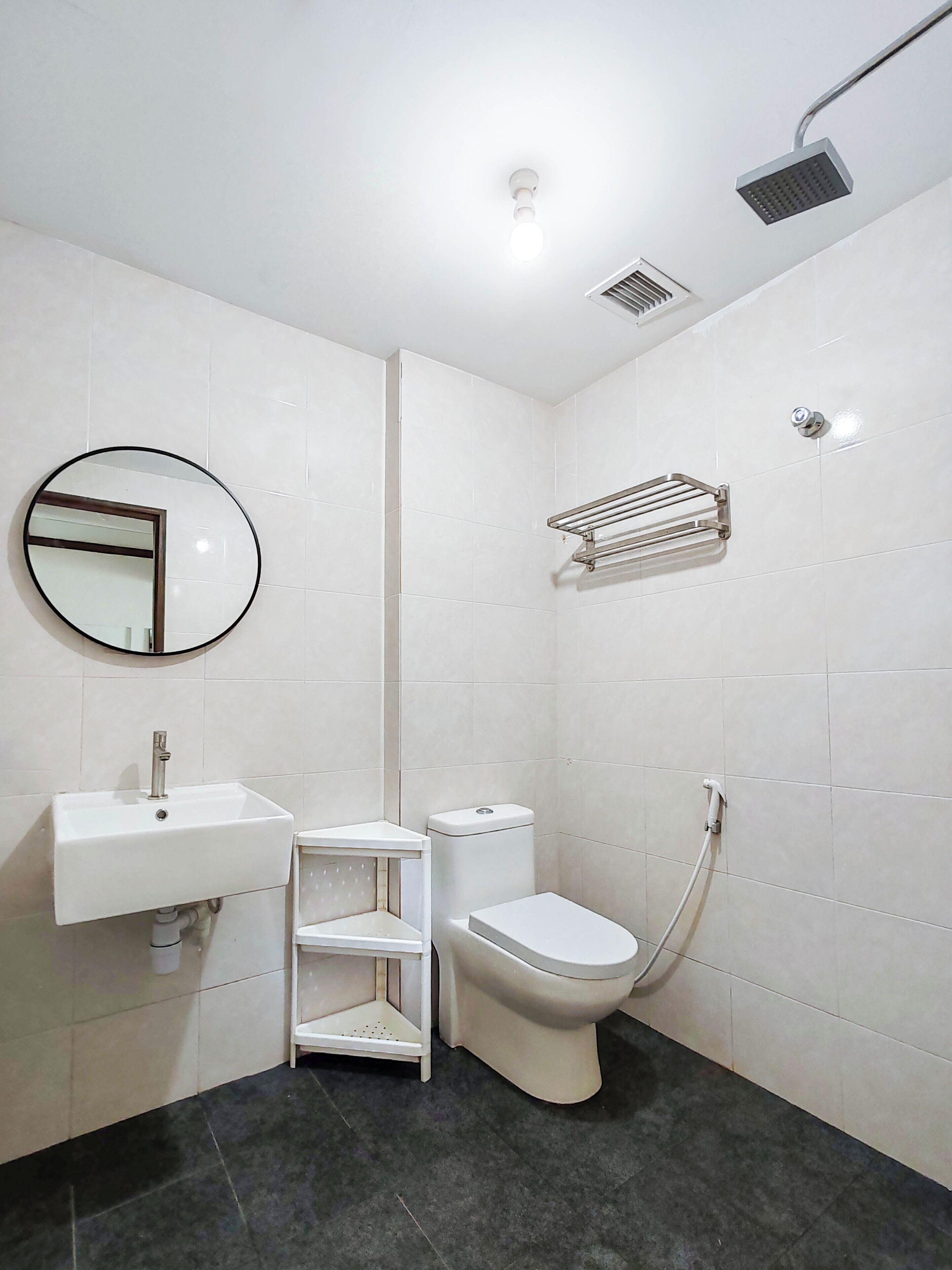 Un baño moderno con lavamanos, inodoro y ducha.