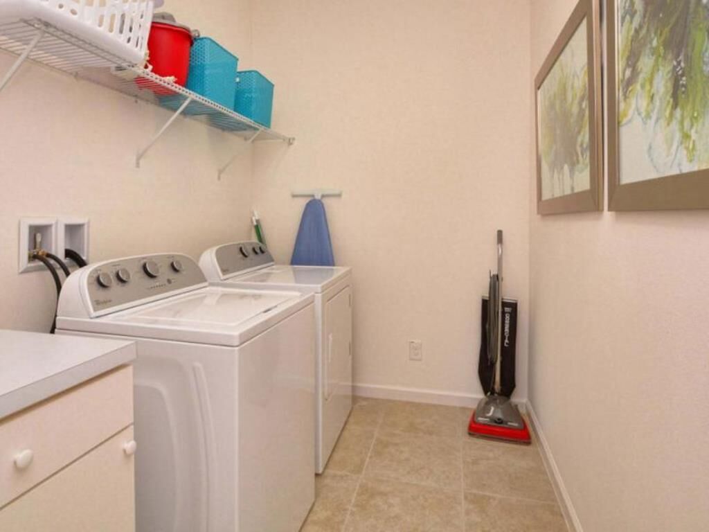 A laundry area with a washing machine, dryer, and a vacuum cleaner.